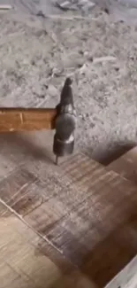 Rustic hammer on wood in a dusty workshop setting.