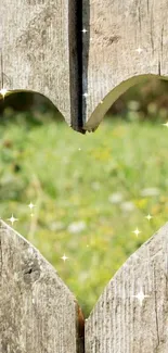 Heart-shaped cutout in wood showing a green field.