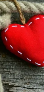 Red fabric heart on rustic wooden surface wallpaper.