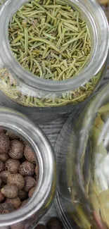 Rustic spice jars filled with assorted herbs and spices on a wooden table.