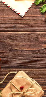 Rustic holiday themed phone wallpaper with pine cones and gift box on wood.
