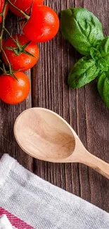Fresh tomatoes, basil, and wooden spoon on wooden table.