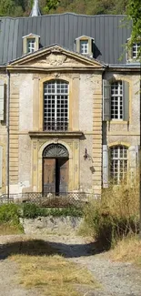 Rustic mansion with stone facade and greenery.