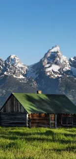 Rustic cabin with green roof in snowy mountain landscape wallpaper.