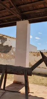 Rustic wooden sculpture in outdoor courtyard with blue sky.