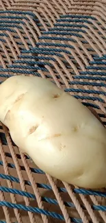 A potato on a rustic woven surface wallpaper.