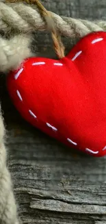 Rustic red stitched heart on wooden background wallpaper.