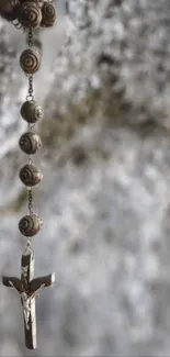 Rustic rosary and cross with stone background creating a serene mobile wallpaper.