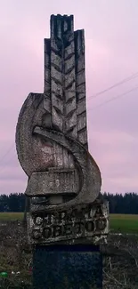 Sculpture in a rural landscape with grayish sky.