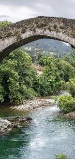 A tranquil stone bridge over a lush, green river.