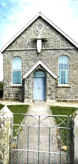 Stone church with arched windows and a rustic path in rural setting.