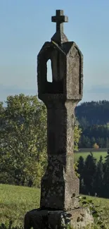 Stone monument in sunny countryside landscape.