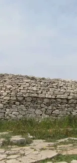 Rustic stone wall beneath a clear blue sky.