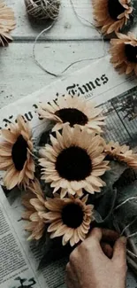 Bouquet of sunflowers on newspaper in rustic setting.