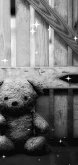 Monochrome teddy bear against wooden barn backdrop.