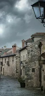 Rustic stone village street under cloudy skies.