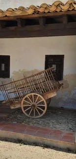 Wooden rustic cart under clay roof in a rural setting.