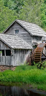 Rustic watermill surrounded by lush green landscape.