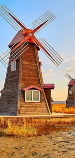 Rustic windmills in a warm golden landscape with bright blue sky.