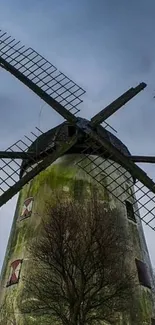 Wallpaper of a rustic windmill under a grayish blue sky.