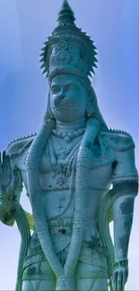 Statue of Hanuman with sky background in serene tones, perfect for mobile wallpaper.