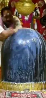 Sacred Lingam being ritually anointed in a vibrant temple setting.