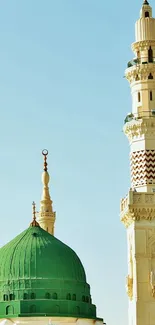 Scenic view of a mosque with a green dome and minarets against a blue sky.