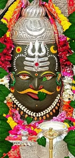 Sacred sculpture surrounded by colorful flowers and leaves.