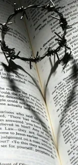 Open book with barbed wire heart shadow.