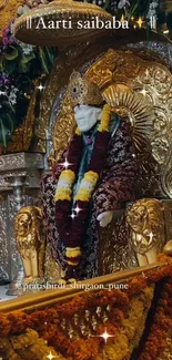 Sai Baba sits on a gold throne adorned with flowers in a sacred shrine setting.