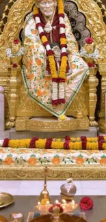 Sai Baba seated in a golden shrine adorned with flowers and sacred decor.