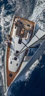 Aerial view of a yacht sailing on a vibrant blue ocean, capturing an adventurous sea journey.