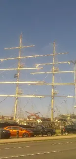 Majestic sailboat docked at city harbor under clear blue sky.