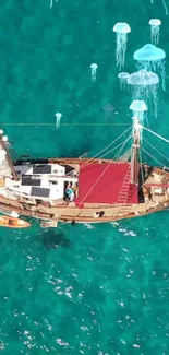 Aerial view of sailboat on turquoise sea with jellyfish.