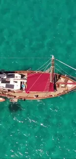 Top view of sailboat on turquoise ocean waters, showcasing nautical elegance.