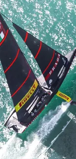 Sailboat racing over turquoise sea from an aerial view.