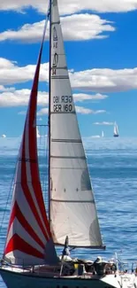 Sailboat on blue ocean with clear sky.