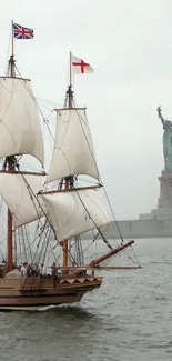 Vintage sailing ship near Statue of Liberty with a gray, misty sky.