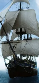 A majestic sailing ship glides over the open sea with billowing white sails.