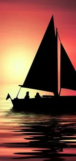 Sailboat silhouette on orange sunset reflecting on calm waters.