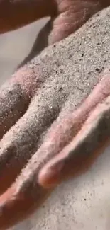 Close-up of a hand covered in sand