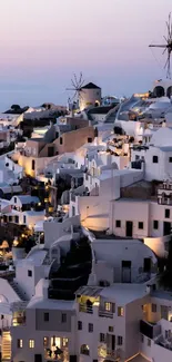 Santorini at dusk with lit windmills and white buildings