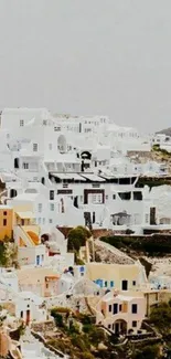 Santorini cliffside homes with white buildings and blue sky background.