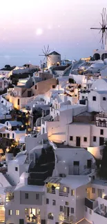 Santorini in the evening with scenic sunset view over white-washed buildings.