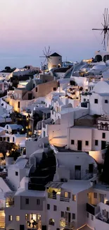 Scenic Santorini dusk view with windmills and classic architecture.