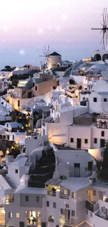 Santorini village at dusk with lights illuminating the serene Greek landscape.