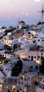 Santorini illuminated at dusk, showcasing white-washed buildings and windmills.