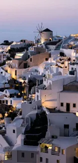 Evening view of Santorini's white buildings under a pastel sky.