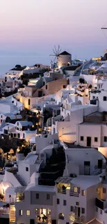 Stunning Santorini evening with windmills and white buildings at sunset.