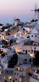 Stunning Santorini sunset with windmills and white-washed architecture.